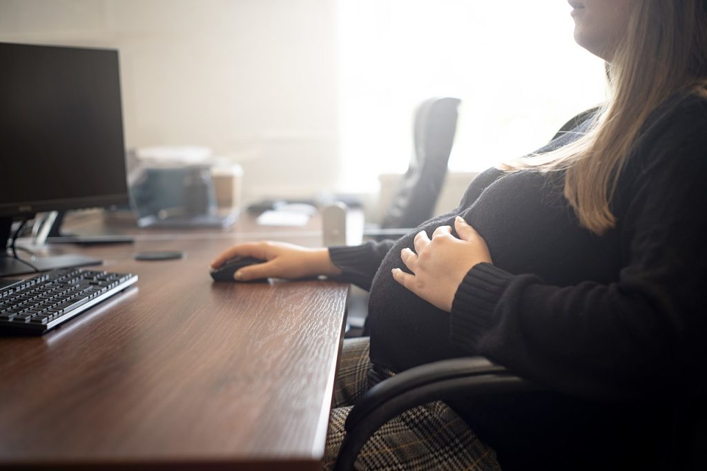Pregnant worker at a computer